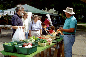 Chuck Couture talking with customers at a farmers market
